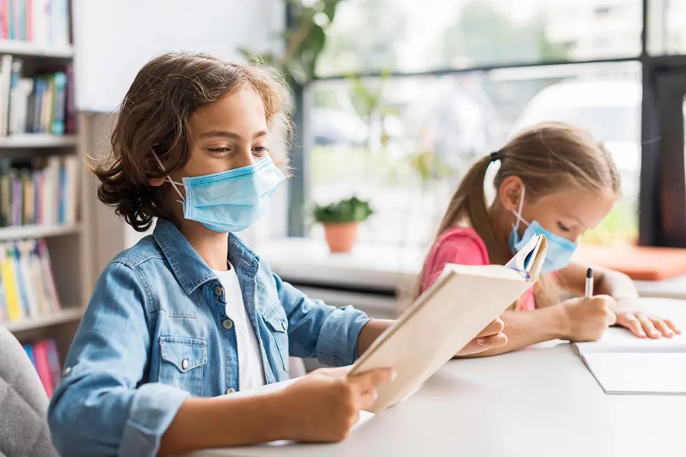 Students studying in a classroom during high pollution with a mask on